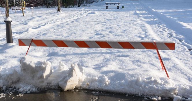 Emergency barier blocking recreation zone covered with snow