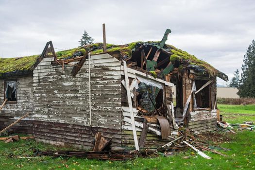 Old abandoned house in disrepair on cold fall day before final demolition