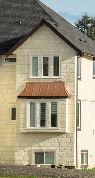 Facade of new residential house with unpaved driveway in front