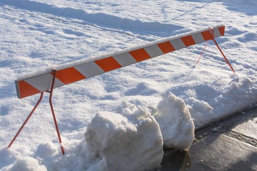 Emergency barier blocking recreation zone covered with snow