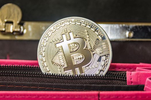 Crypto money metal coin in the pocket of open wallet