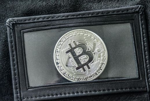 Bitcoin in leather wallet under transparent film