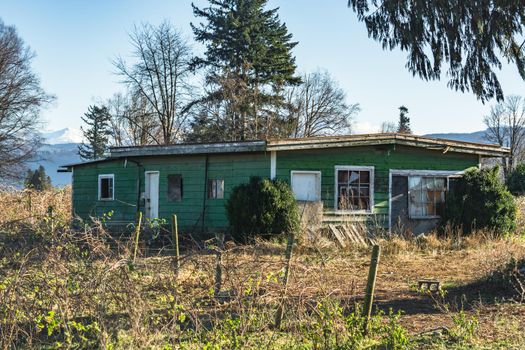 Old abandoned house in disrepair on cold fall day