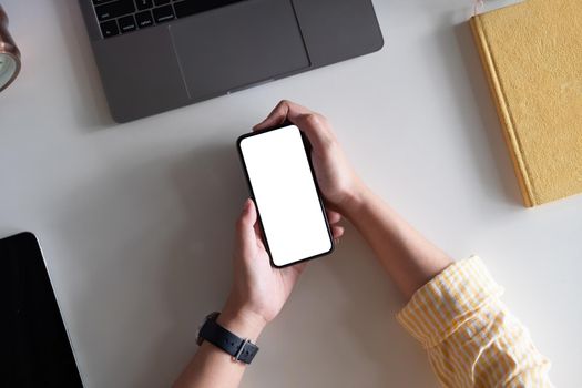 Top view Woman sitting and holding blank screen mock up mobile phone