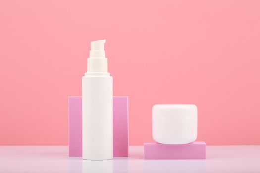 Set of cosmetic products for skin and body care on white table against bright pink background. Concept of health care and beauty