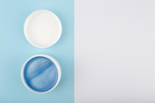 Flat lay with opened face mask with sea minerals on blue and white background with copy space. Concept of natural beauty products with sea minerals