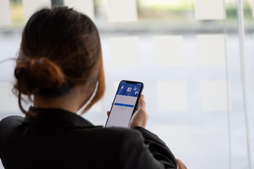CHIANG MAI, THAILAND - JAN 17, 2021: Facebook social media app logo on log-in, sign-up registration page on mobile app screen on iPhone smart devices in business person's hand at work