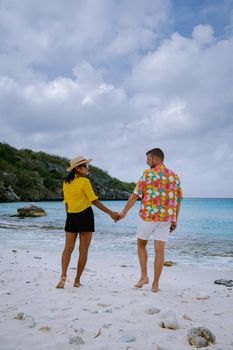 Aerial view of the coast of Curacao in the Caribbean Sea with turquoise water, white sandy beach, coral reef Playa Cas Abao Curacao, couple mid age european man and asian woman during vacation