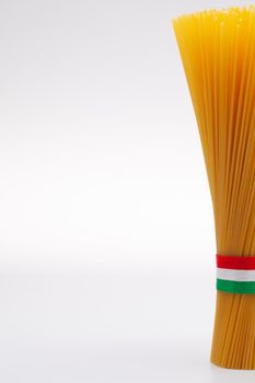 Bundle of spaghetti and Italian flag on the white background.