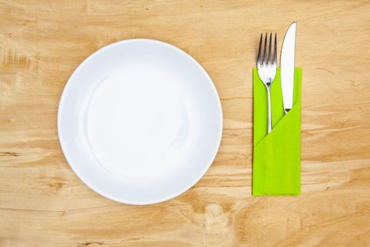 White plate on the wooden table.Top view. Flat Lay Image.