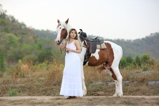 Women on skirt dress Riding Horses On field landscape Against Sky During Sunset