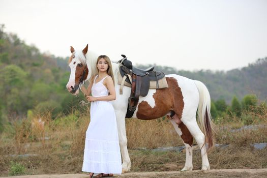 Women on skirt dress Riding Horses On field landscape Against Sky During Sunset