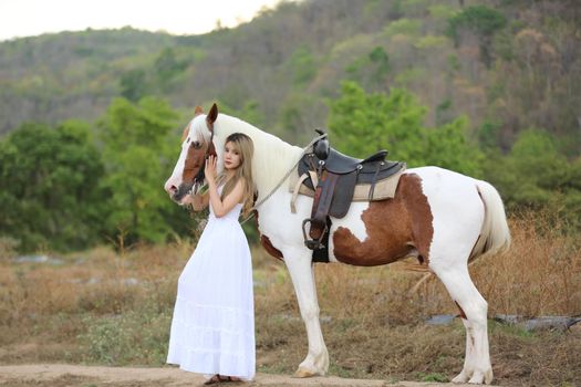 Women on skirt dress Riding Horses On field landscape Against Sky During Sunset