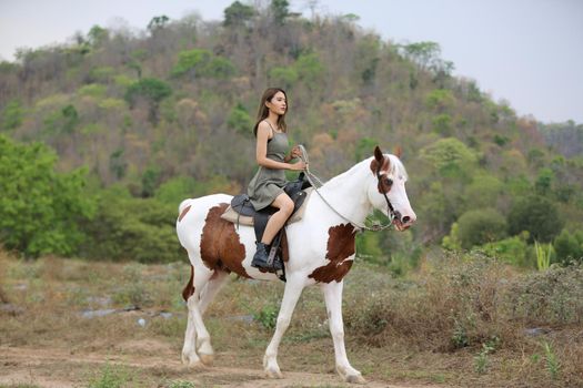 Women on skirt dress Riding Horses On field landscape Against Sky During Sunset