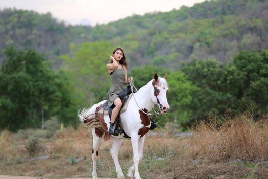 Women on skirt dress Riding Horses On field landscape Against Sky During Sunset