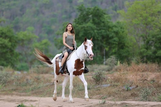Women on skirt dress Riding Horses On field landscape Against Sky During Sunset