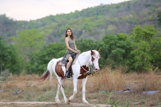 Women on skirt dress Riding Horses On field landscape Against Sky During Sunset