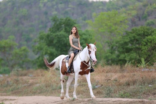Women on skirt dress Riding Horses On field landscape Against Sky During Sunset