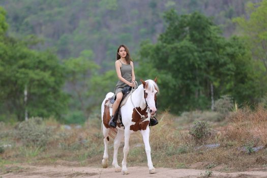 Women on skirt dress Riding Horses On field landscape Against Sky During Sunset