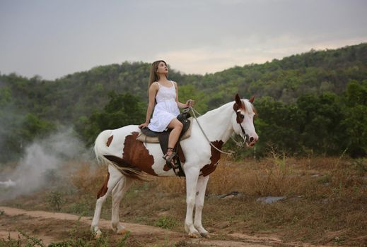 Women on skirt dress Riding Horses On field landscape Against Sky During Sunset