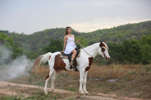Women on skirt dress Riding Horses On field landscape Against Sky During Sunset