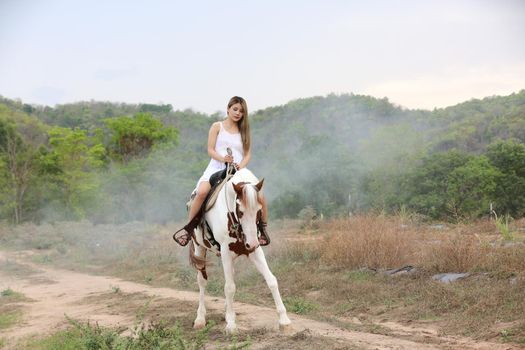 Women on skirt dress Riding Horses On field landscape Against Sky During Sunset