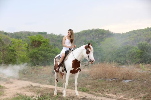 Women on skirt dress Riding Horses On field landscape Against Sky During Sunset