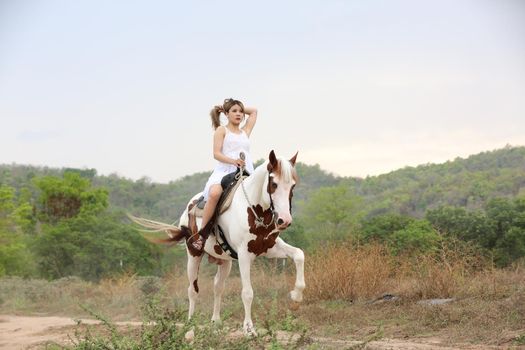 Women on skirt dress Riding Horses On field landscape Against Sky During Sunset