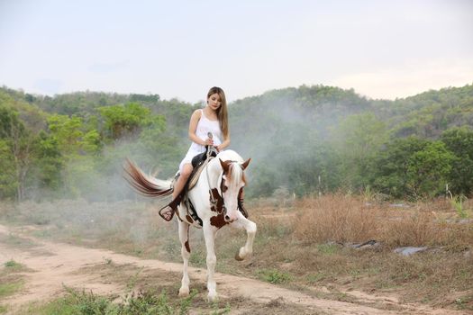 Women on skirt dress Riding Horses On field landscape Against Sky During Sunset