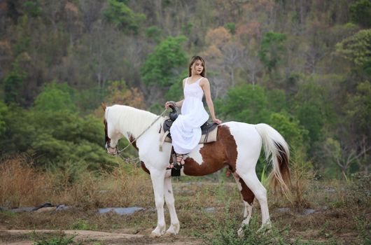 Women on skirt dress Riding Horses On field landscape Against Sky During Sunset