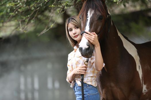 A woman in a cowgirl style sits in a horse ranch with a western farm environment.