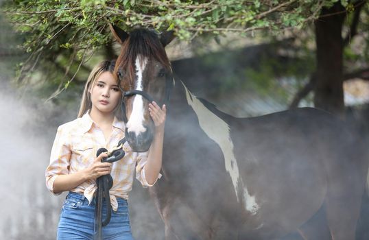 A woman in a cowgirl style sits in a horse ranch with a western farm environment.