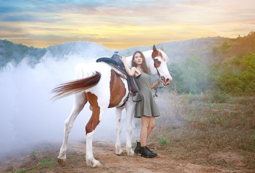 Woman with horse standing on field