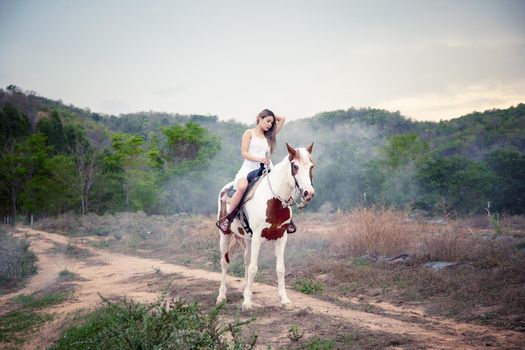 Woman with horse standing on field