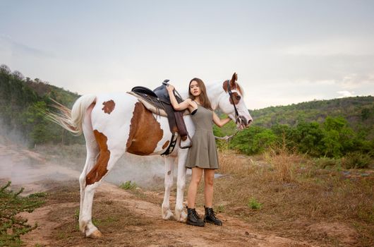 Woman with horse standing on field