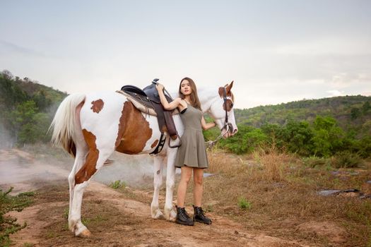 Woman with horse standing on field