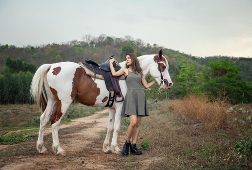 Woman with horse standing on field
