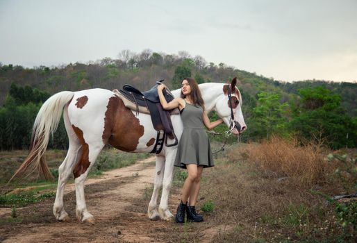 Woman with horse standing on field