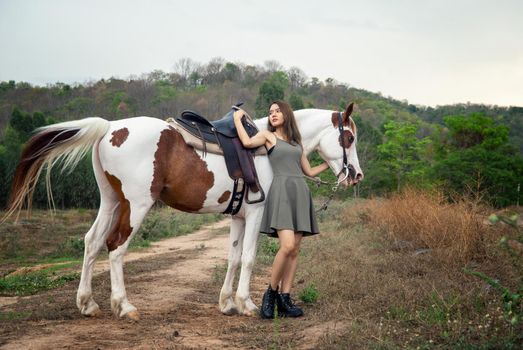 Woman with horse standing on field