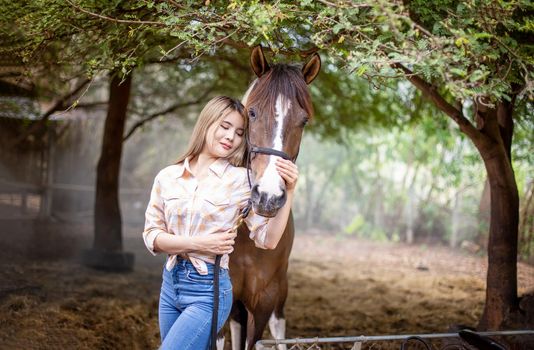 A woman in a cowgirl style sits in a horse ranch with a western farm environment.