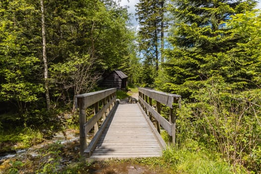 Small wooden bridge next to wooden bower on mountain trail in Giant Mountains