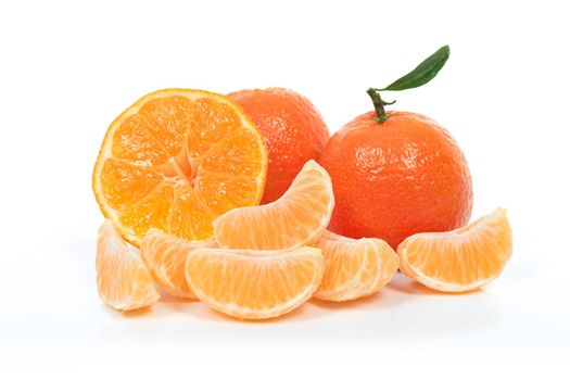 Tropical fruit composition - fresh  fruits and pieces of orange or tangerine with leaves isolated on a white background