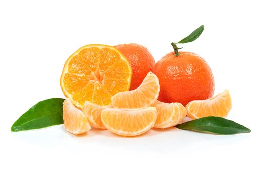 Tropical fruit composition - fresh  fruits and pieces of orange or tangerine with leaves isolated on a white background