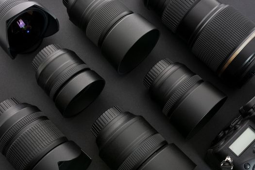 Large collection of professional and modern photographic equipment on a black background (low key).