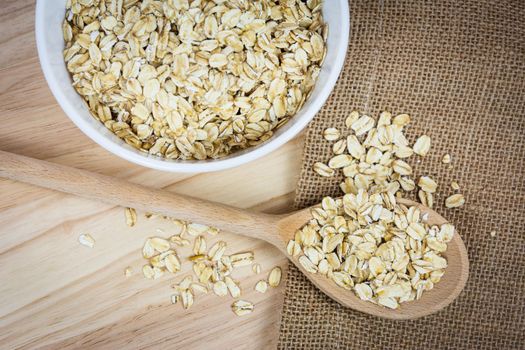 Top view of oatmeal flakes on a wooden table in a rustic style