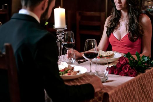 Attractive couple in love is dating and drinking wine during romantic dinner in the restaurant.