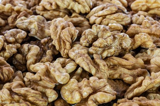 Background of shelled dried walnuts in close-up (high details)