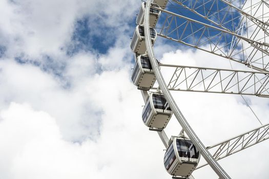 Part of a big ferris wheel on a cloudy sky background with copy space.