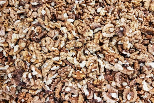 Background of shelled dried walnuts in close-up (high details)