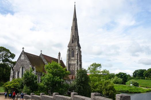 Copenhagen, Denmark - July 24, 2017: Tourists visiting famous St Albans Anglican Church in Copenhagen.  Church designed by Arthur Blomfield in Gothic Revival style and built in 1887.